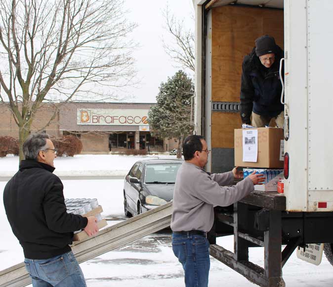 Loading the Salvation Army truck with the Sure Flow Holiday Food Drive contributions