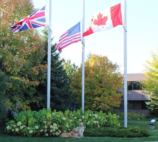 Odus and Acer in front of flags at half mast